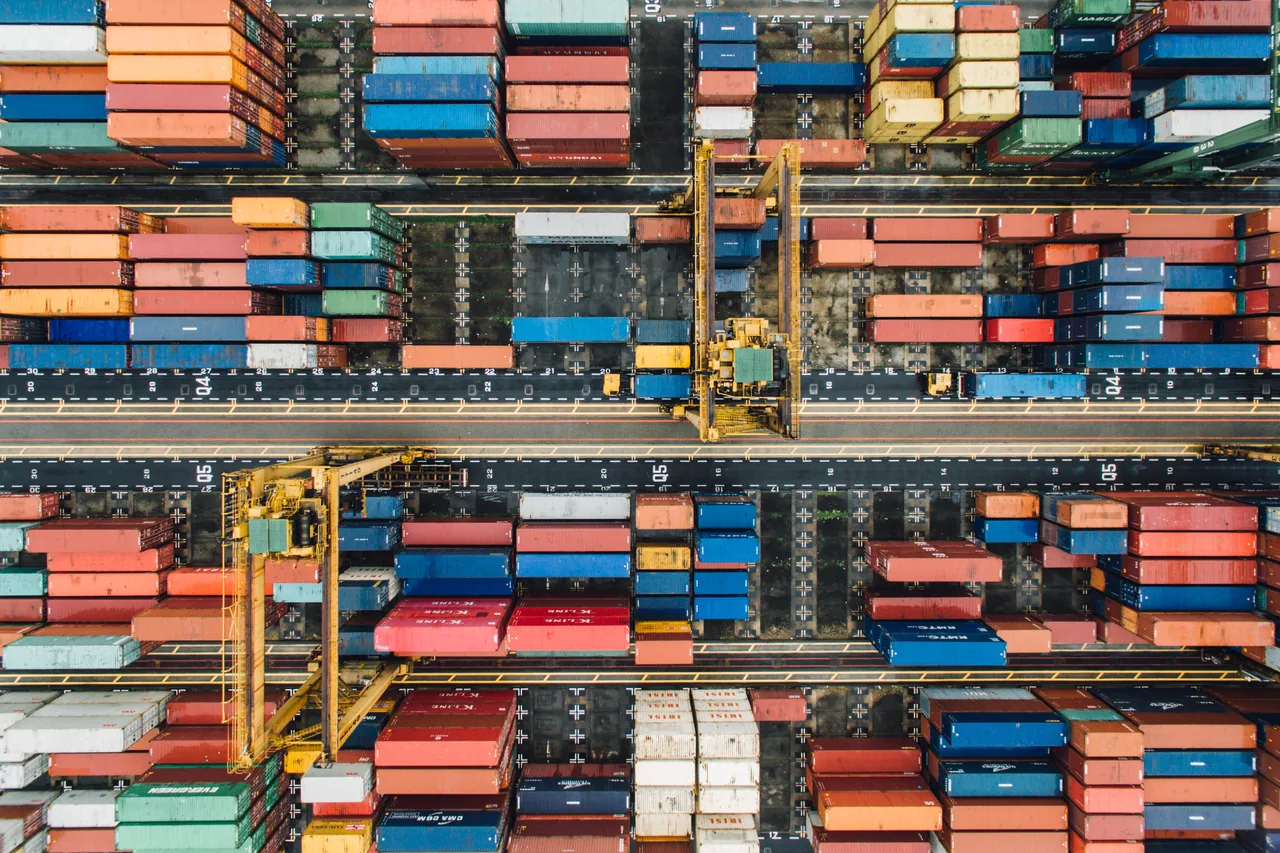 An overhead view of shipping containers arranged at an international cargo terminal